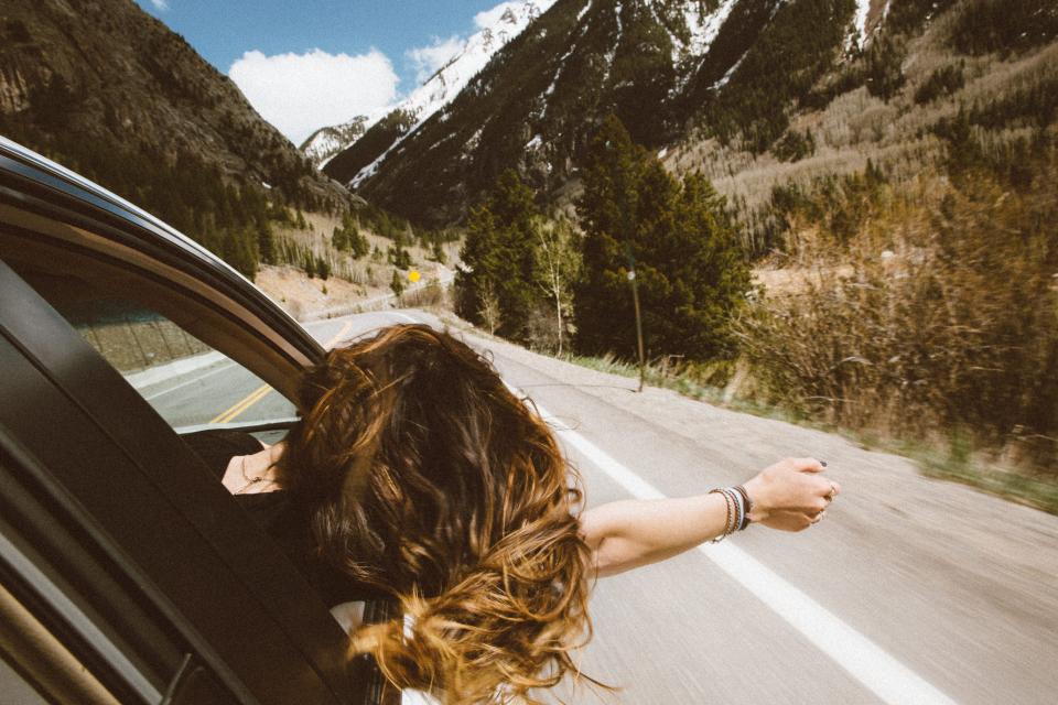 Bras tendu par la fenêtre d'une voiture sur la route
